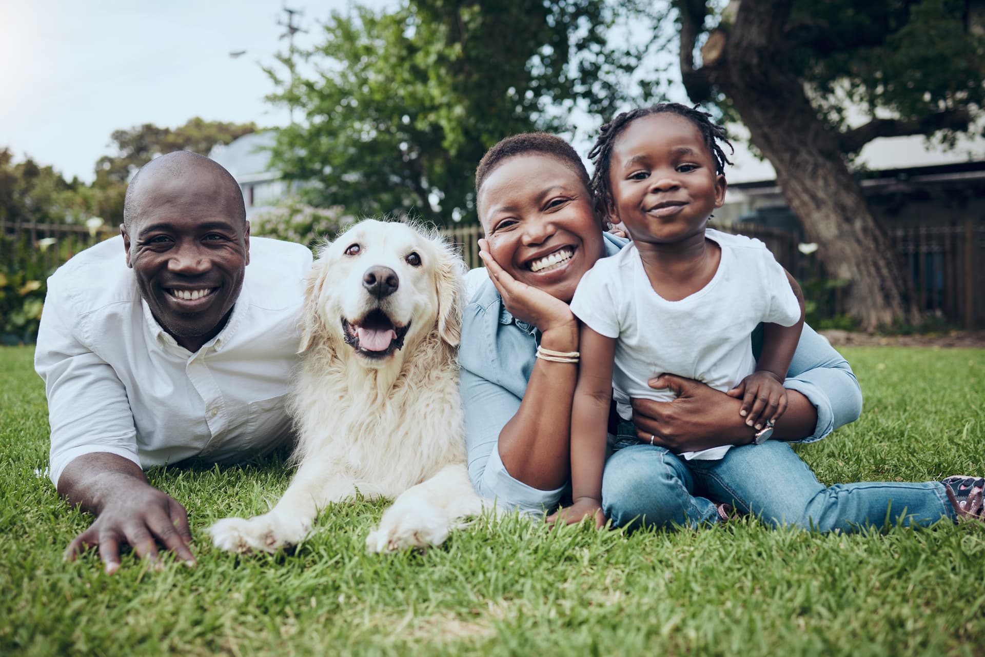 A happy family with a dog, enjoying time outdoors on the grass